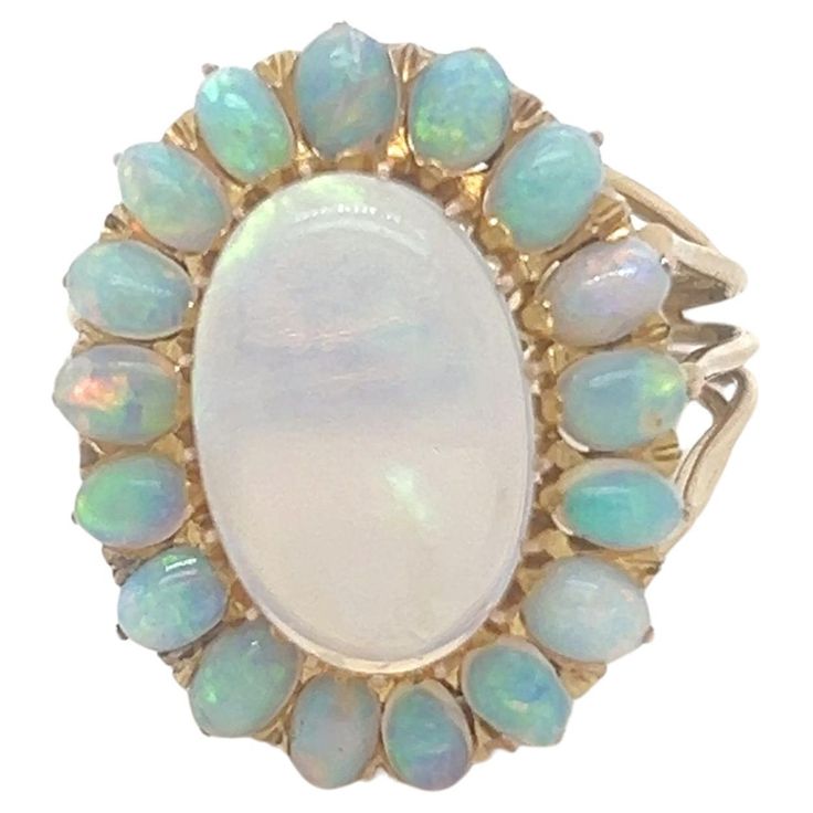 A White Solid Crystal Opal Oval Cluster Ring, with an oval opal claw set in 18ct yellow gold within a border of 17 small oval solid white crystal opals on a five wire band. Centre Opal 2.00ct (estimated), 13.3 x 9.1 x 2.4mm Small opals 3.5 x 2.5mm. Metal: 18ct Yellow Gold Carat: 2.00ct Colour: N/A Clarity: N/A Cut: N/A Weight: 7.72 grams Engravings/Markings: Stamped 18K Size/Measurement: Ring Size O 1/2 Current Condition: Excellent - Consistent with age and use. Accompanied by: This Bespoke Opal Luxury Elegant Opal Cluster Ring, Luxury Multi-stone Opal Ring, Luxury Gold Multi-stone Opal Ring, Antique Gold Opal Ring With Multi-stones, Luxury Vintage Multi-stone Opal Ring, Crystal Opal, White Solid, White Crystal, Opal Crystal