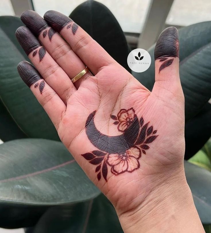 a woman's hand with a bird tattoo on it and a flower in the middle