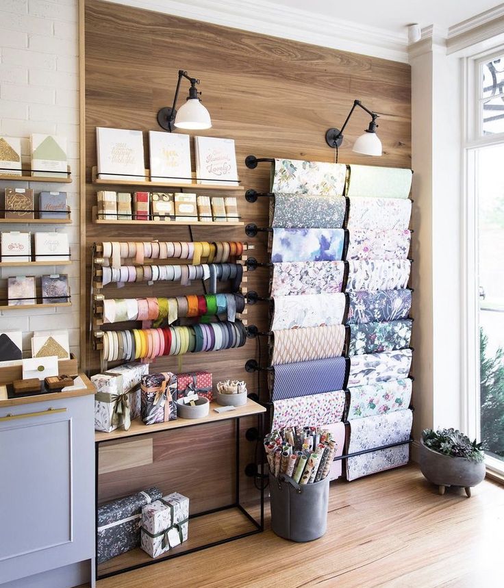 a room with lots of crafting supplies on the shelves and in front of a window