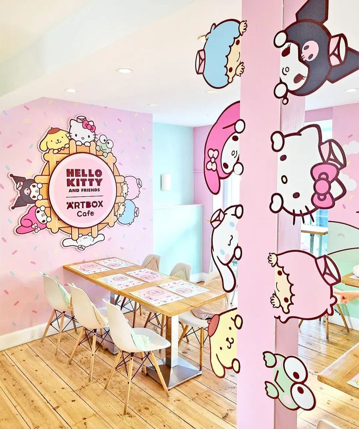 a room with hello kitty wall decals on the walls and tables in front of them