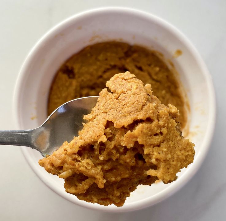 a white bowl filled with food and a spoon