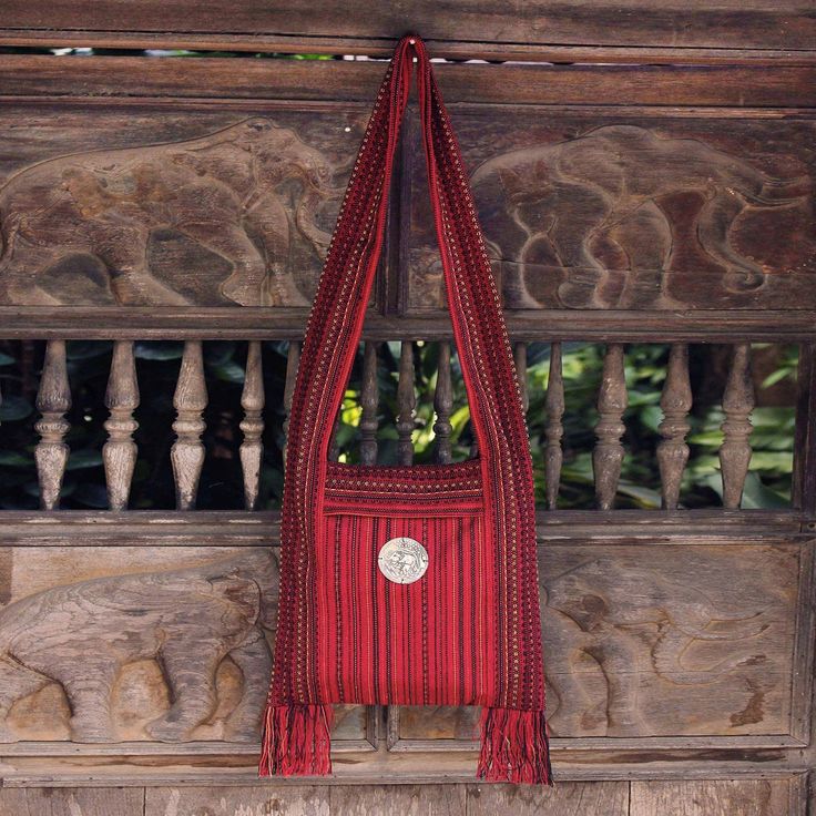 Jiap Rojjana designs a shoulder bag in rich deep crimson featuring elephants detailed in aluminum repousse. The medallion is sewn on the bag's exterior pocket which features a zipper closure. The cotton bag is woven on a traditional loom by Karen hill tribe weavers in northern Thailand. Lined in black cotton the bag closes with a zipper. Elephant Purse, Elephant Bag, Red Shoulder Bag, Embroidered Shoulder Bag, Cotton Handbag, Embroidered Handbag, Red Clutch, Lucky Elephant, Northern Thailand