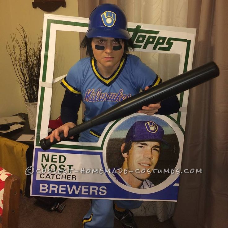 a man in a baseball uniform is holding a bat and a sign that says ned yost catcher brewers