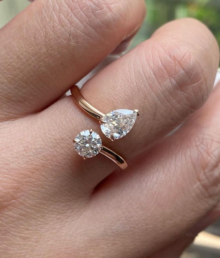 a woman's hand with two engagement rings on it