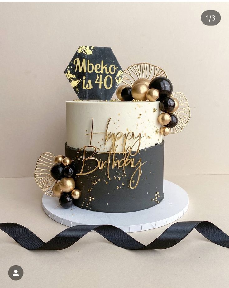 a black and white birthday cake with gold decorations