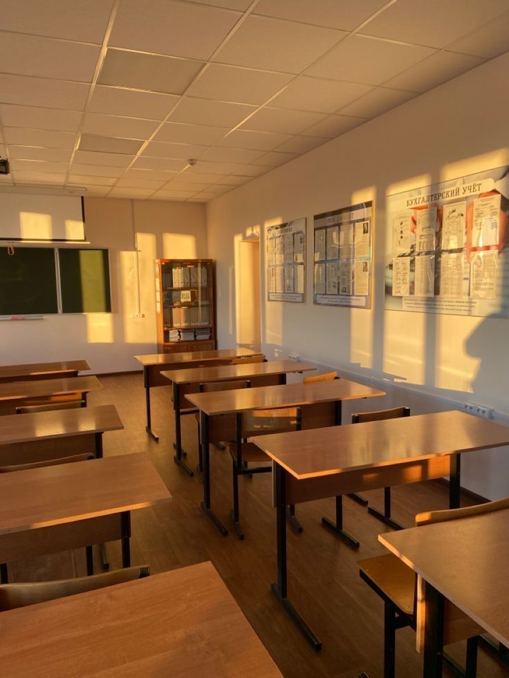 an empty classroom with desks and bookshelves