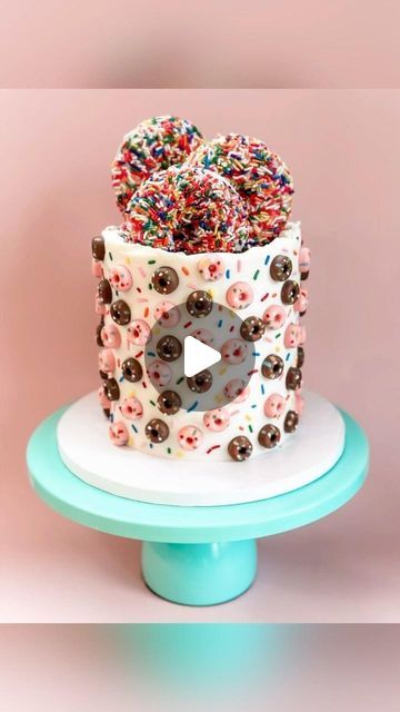 a cake with sprinkles on it sitting on top of a blue stand