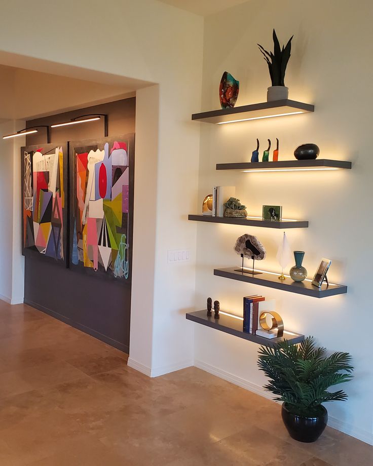 an empty room with shelves and vases on the wall