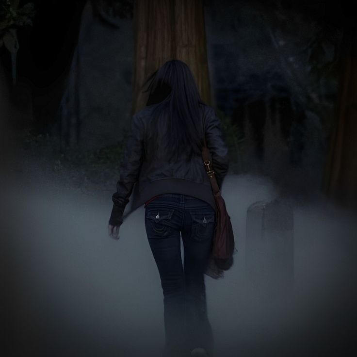 a woman is walking through the fog with her back turned to the camera and luggage behind her