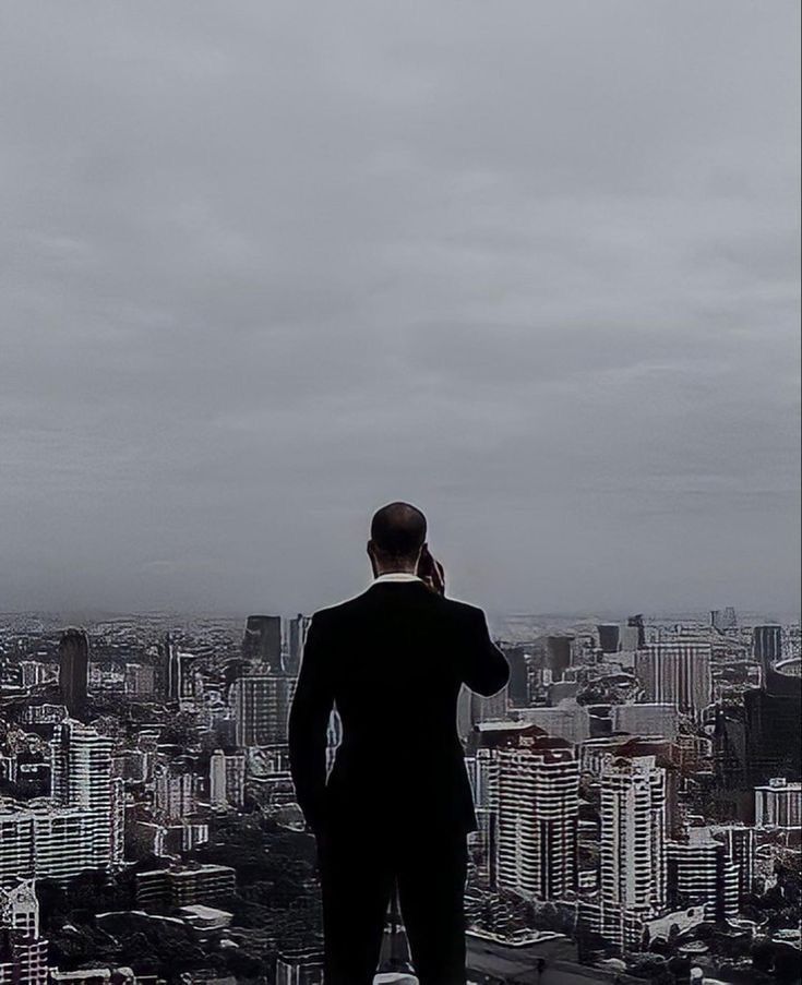 a man standing on top of a tall building looking out at the city below him