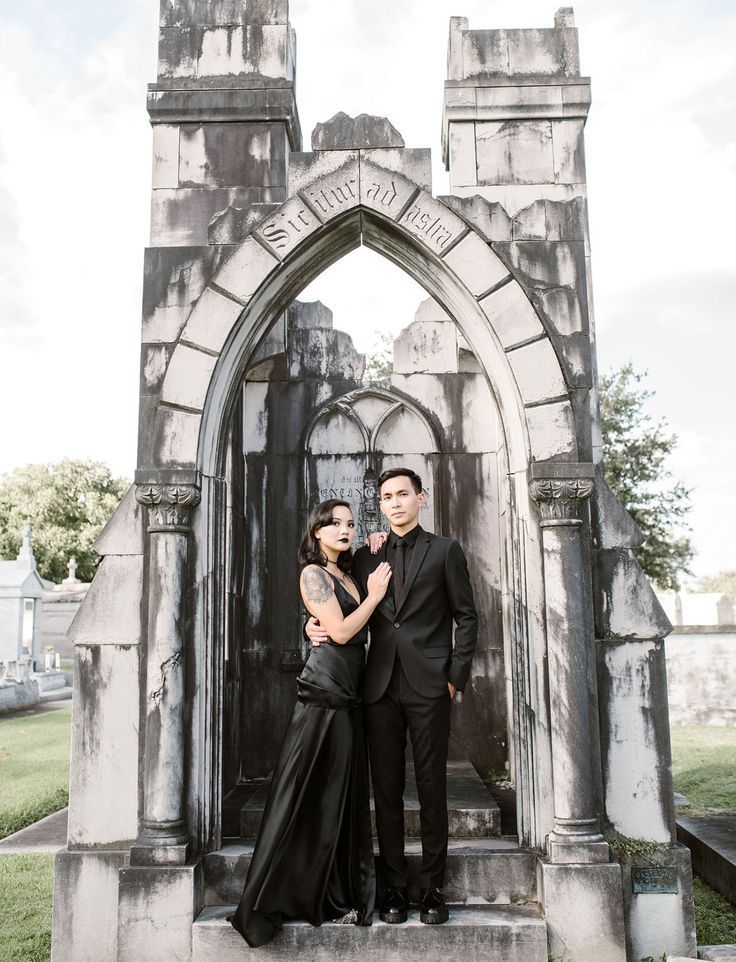 a man and woman standing in front of an arch