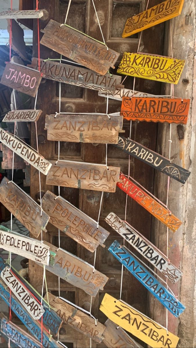 several wooden signs hanging from the side of a building