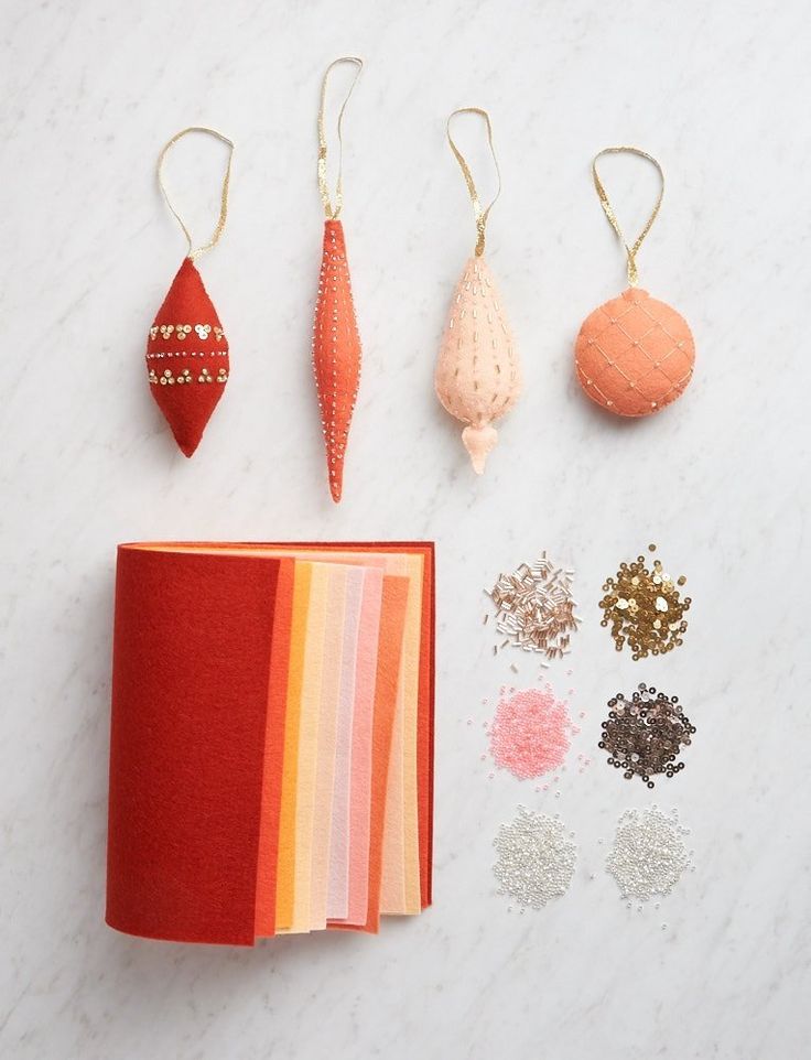 some ornaments are laying out on a white counter top, including an ornament