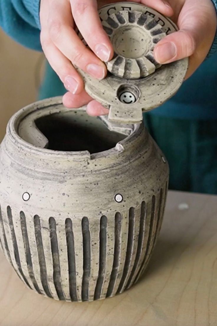 a person is working on a vase with holes in the bottom and sides that are made from clay