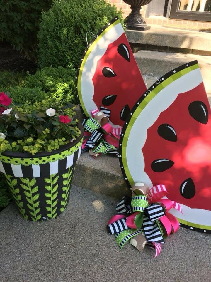 two watermelon plates sitting on the ground next to some potted planters