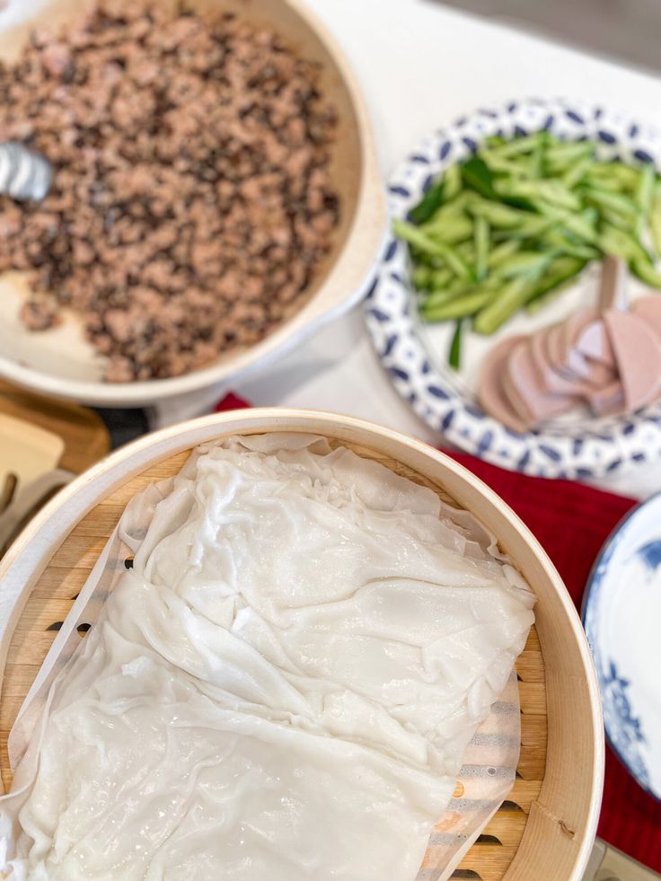 three bowls filled with food sitting on top of a table