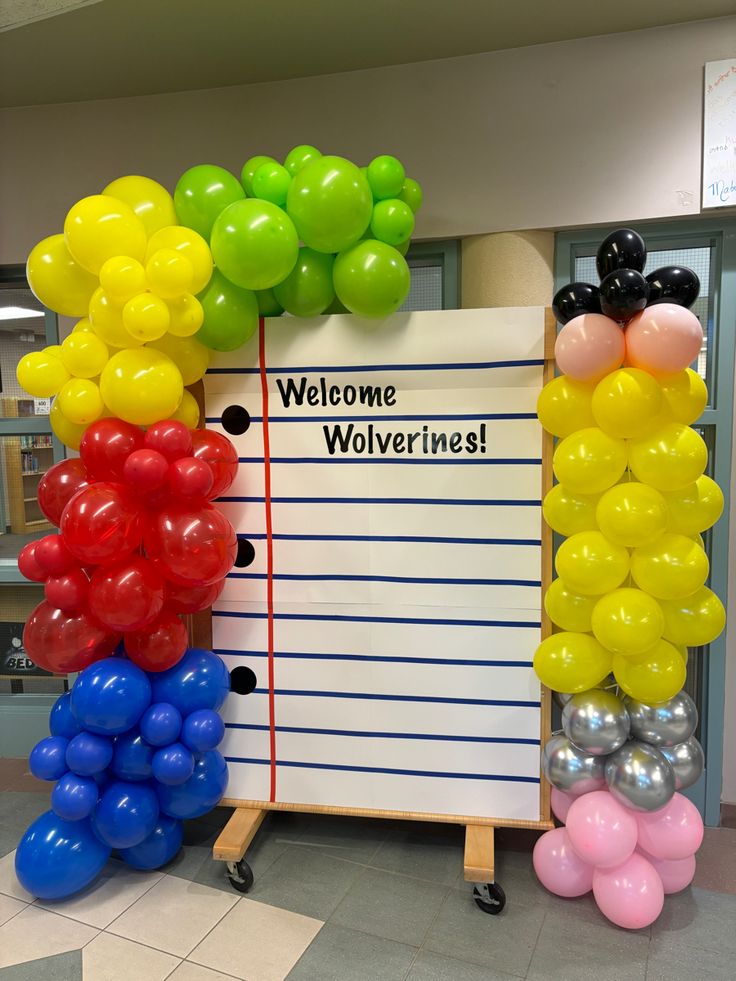 there is a welcome sign with balloons on it