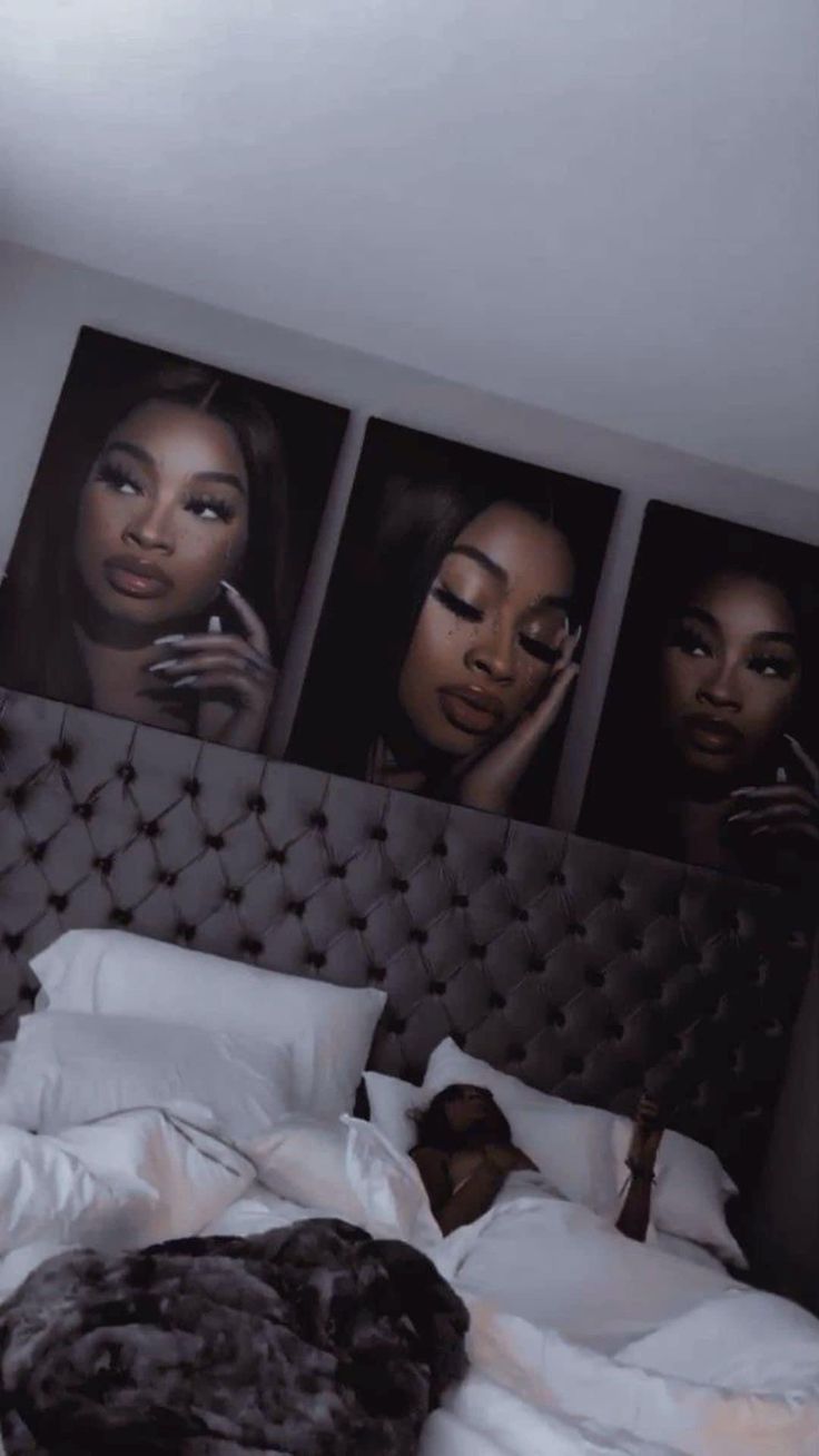 a woman laying in bed with three pictures on the wall above her head and phone to her ear