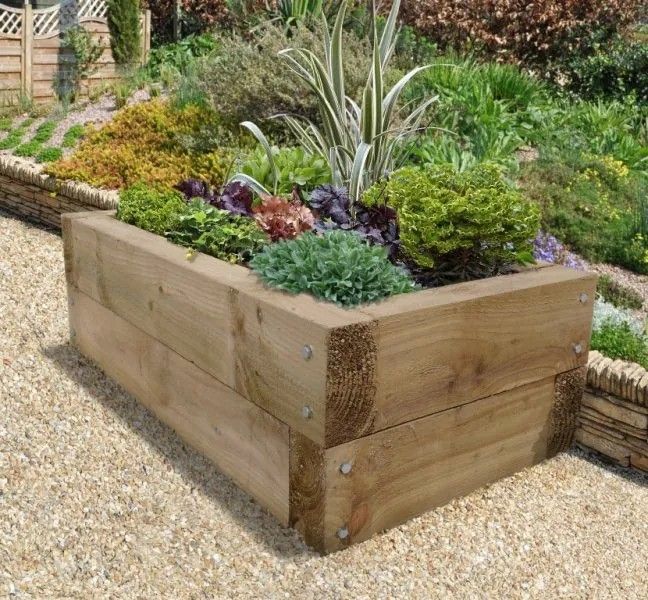 a wooden planter filled with lots of plants