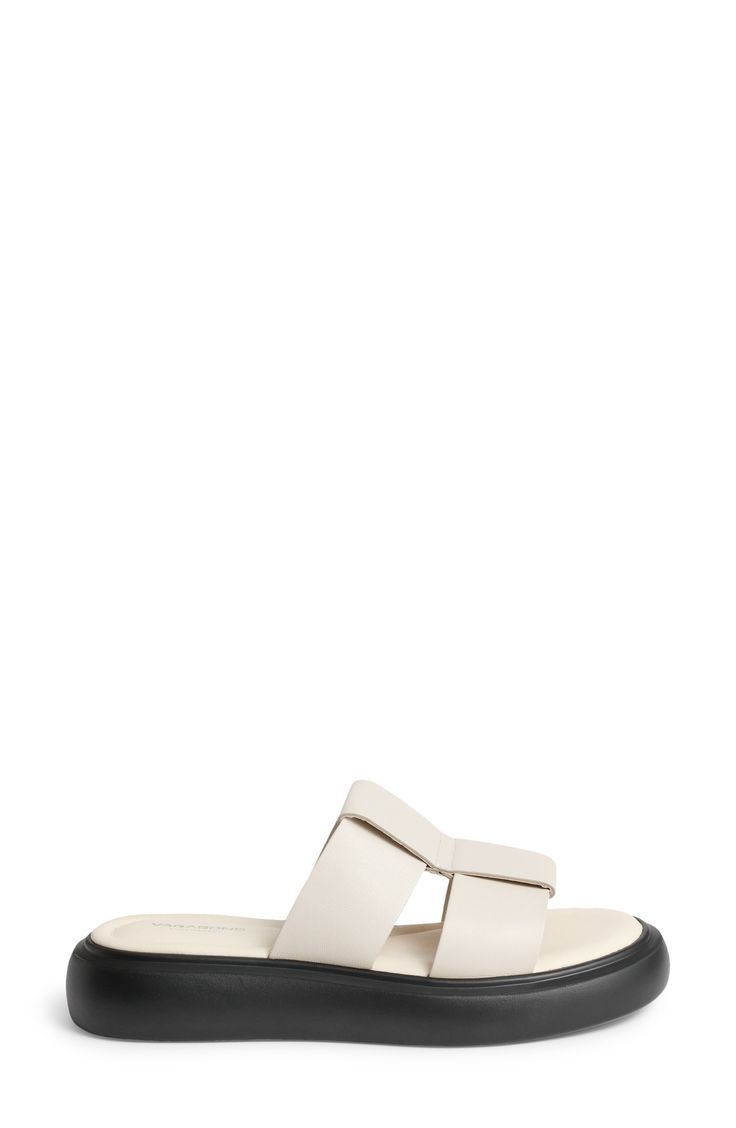 Oversized leather straps kick off a modern slide sandal set atop lightweight padding and a chunky contrast sole. 1 1/2" platform Flat sole Cushioned footbed Leather upper and lining/synthetic sole Imported Classic Slide Sandals With Textured Sole, Modern White Platform Slides, Slip-on Platform Slide Sandals, White Summer Slides With Buckle Closure, White Slides With Buckle Closure, Platform Flats, Slide Sandals, Leather Straps, Womens Sandals