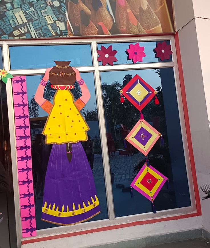 a colorful window display in front of a building with paper flowers and decorations on it