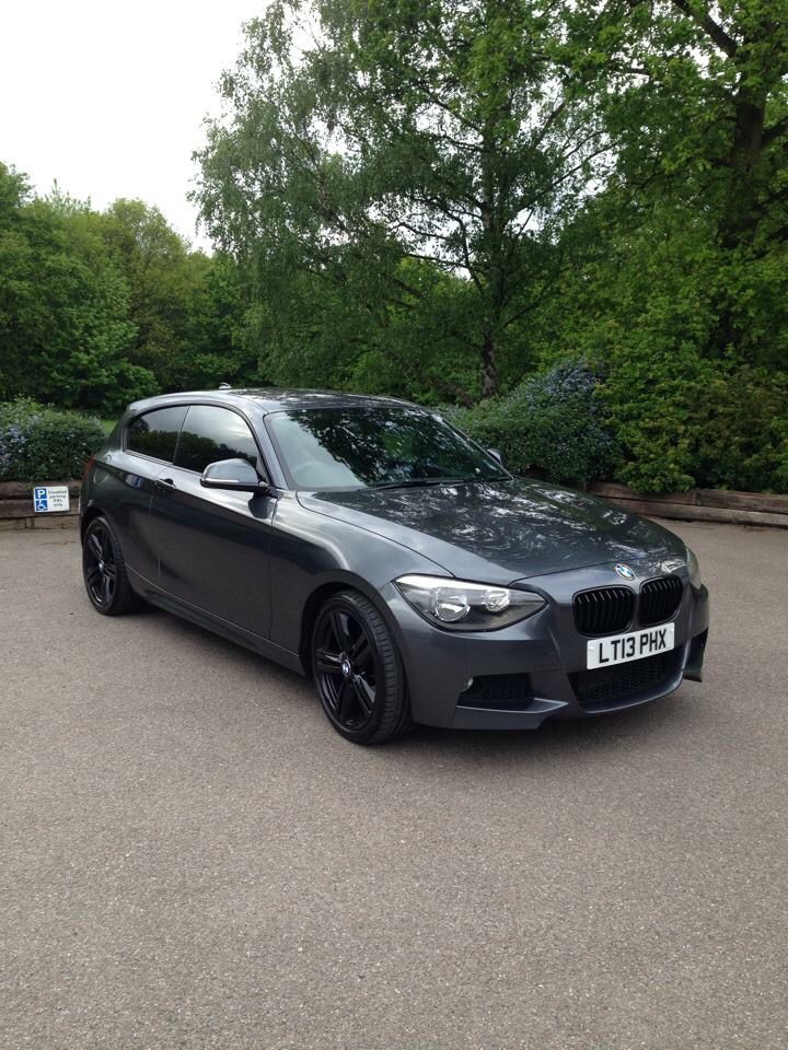 a grey bmw car parked in a parking lot