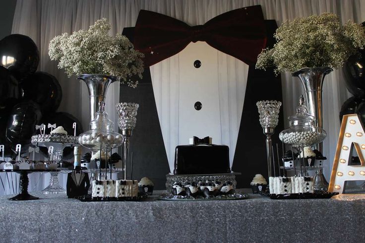 a table topped with vases filled with flowers and black balloons