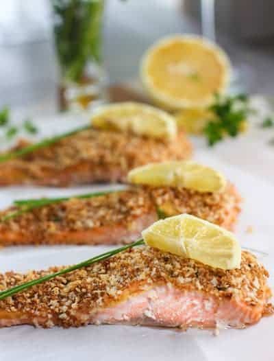 three fish fillets with lemon slices and herbs