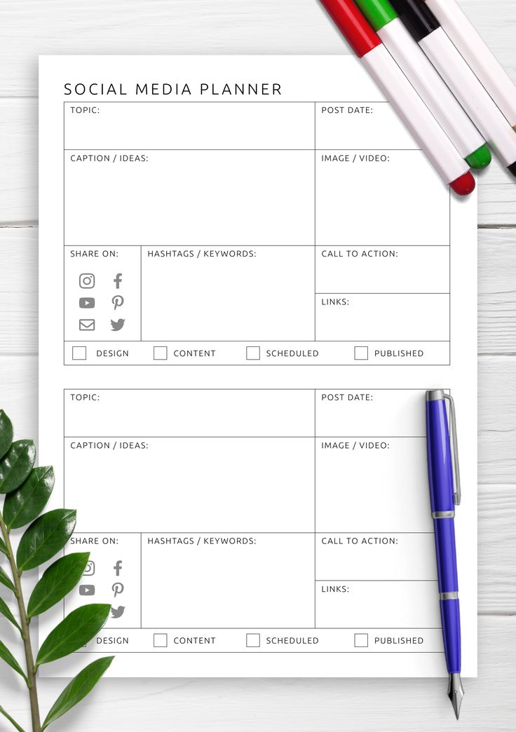 a blank social media planner next to some pens and a plant on a white wooden table