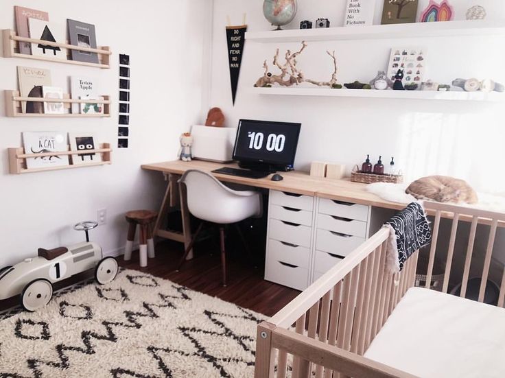 a baby's room with a desk, chair and crib