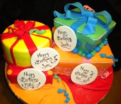 two birthday cakes decorated with presents on top of each other