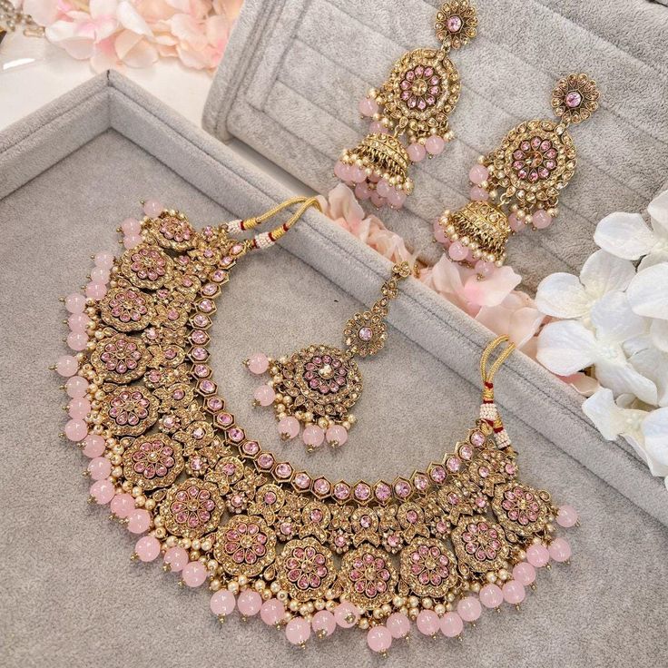 Beautifully flexible Antique Gold intricate necklace set scattered with dazzling golden crystals and light pink bead detailing Comes with matching long jhumka earrings (approx 3 inch length x 1.5 inch width) and matching tikka ( pendant part 2 inch length x 1.5 inch width)  Ready to ship as seen with gift box! Long Jhumka Earrings, Pink Jewelry Set, Wedding Jewelry Sets Bridal Jewellery, Pakistani Bridal Jewelry, Indian Bridal Jewelry Sets, Pretty Jewelry Necklaces, Fancy Jewellery Designs, Asian Jewelry, Bridal Jewelry Collection