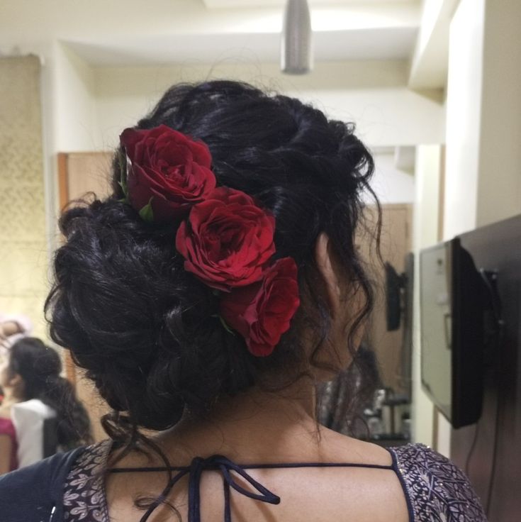 a woman with red roses in her hair