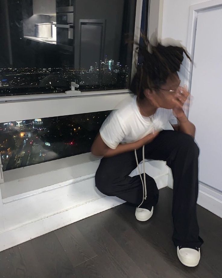 a woman sitting on the ledge of a window sill