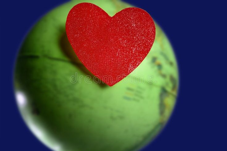 a green apple with a red heart stuck to it's side royalty images and clippings