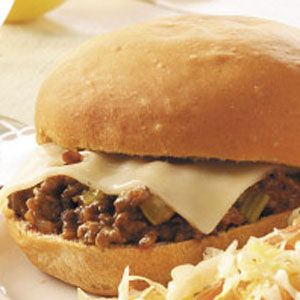 a close up of a sandwich on a plate with coleslaw and potato salad