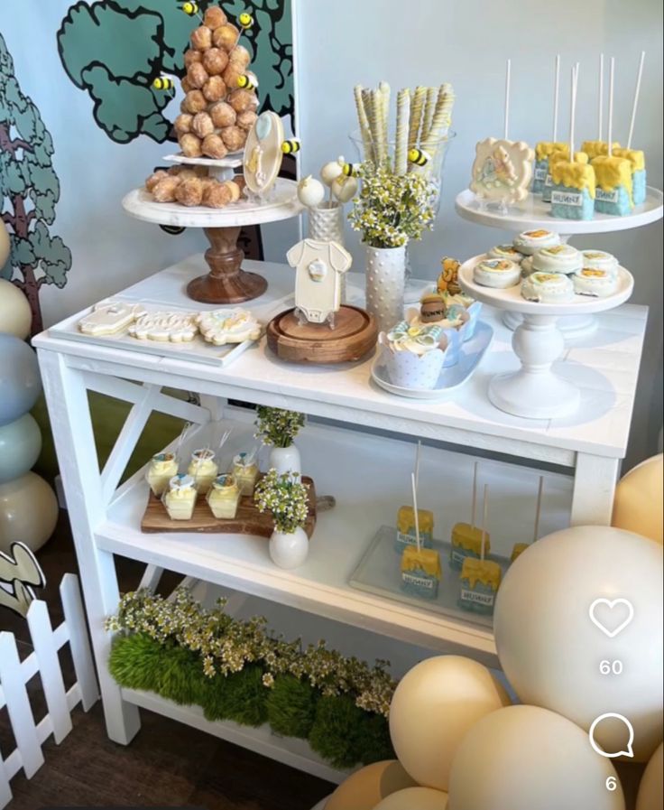 a table with desserts and balloons on it