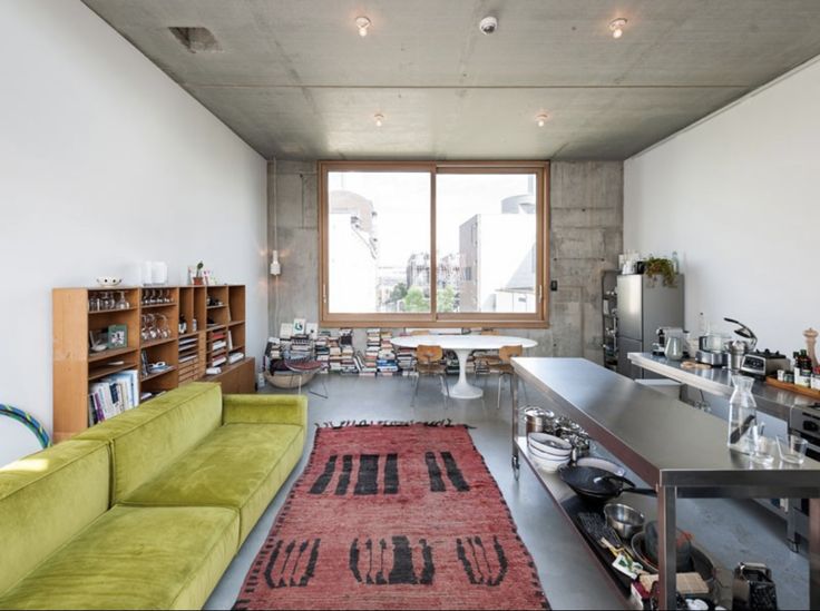 a living room filled with furniture next to a large open floor plan and a big window