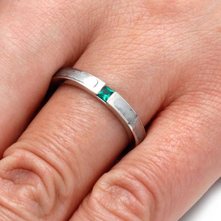 a close up of a person's hand with a wedding ring on their finger