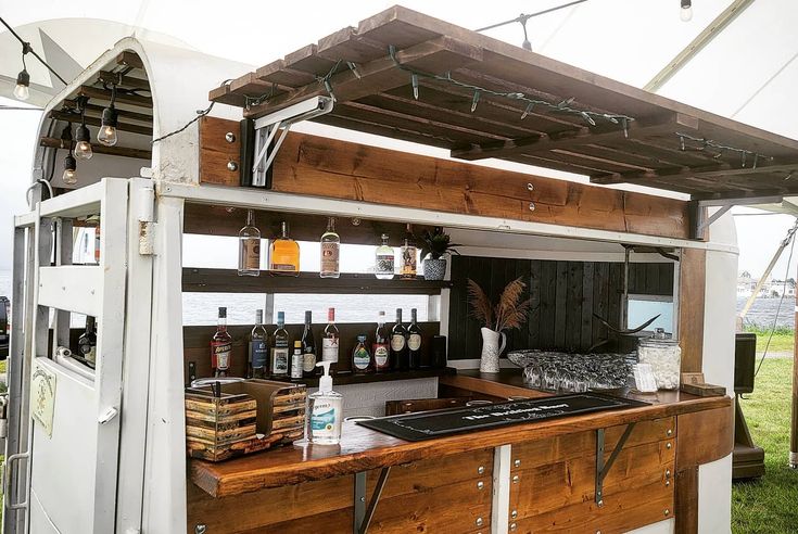 an outdoor bar with shelves and bottles on it