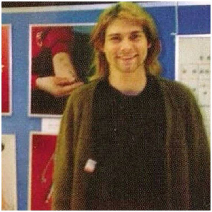 a man standing in front of a wall with pictures on it