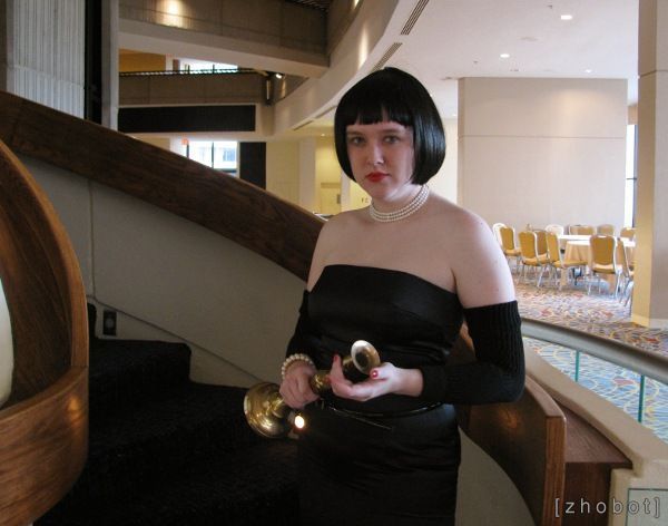 a woman in a black dress is holding an object