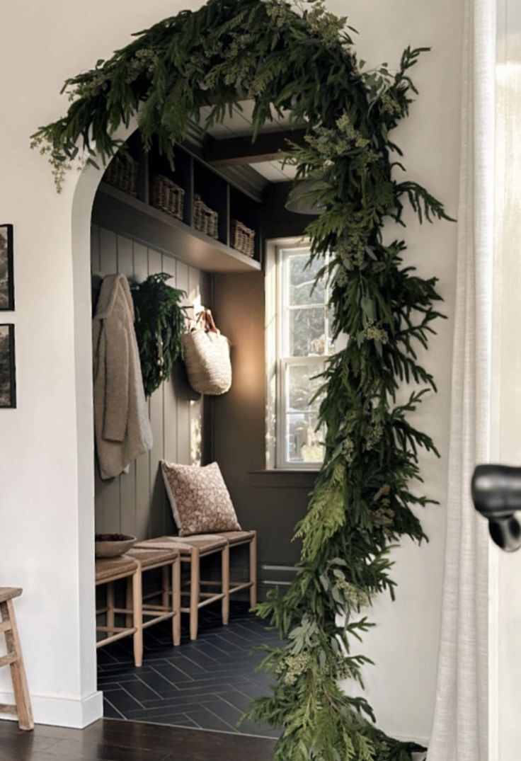 the entryway is decorated with greenery and wooden benches