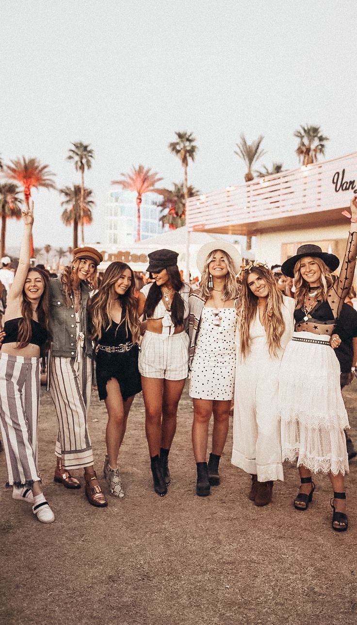 group of young women standing next to each other in front of a building with palm trees