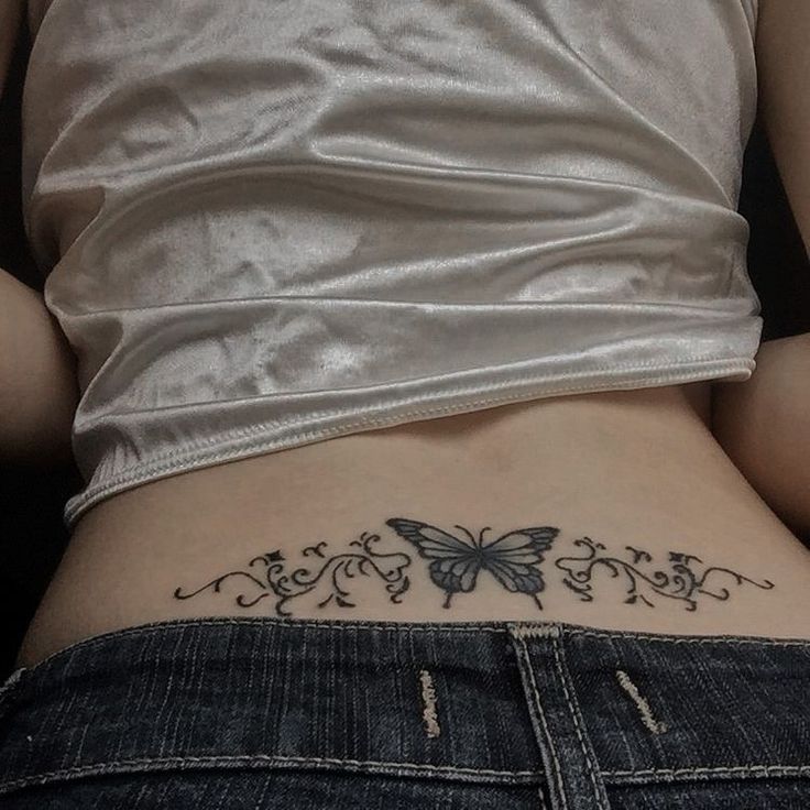 a woman with a butterfly tattoo on her lower back and the bottom part of her stomach