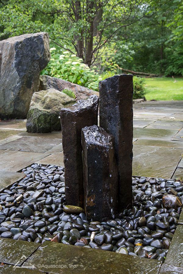 an outdoor fountain with rocks and stones around it