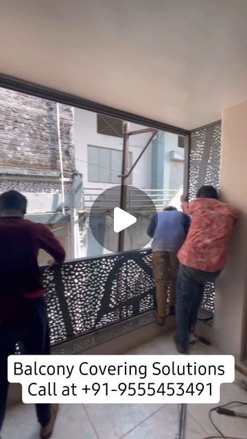 two men are standing on the balcony and one man is pointing at something in front of him