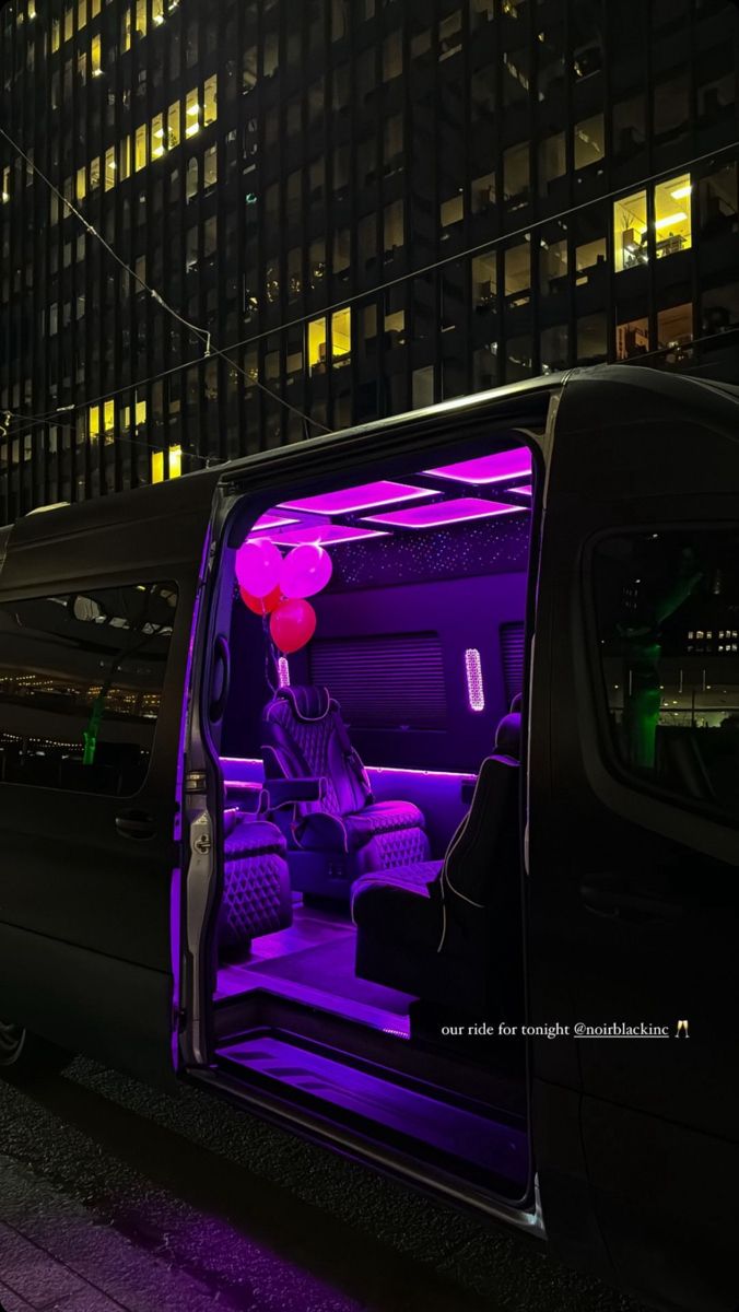 the interior of a van with purple lights and balloons on it's windows is lit up at night