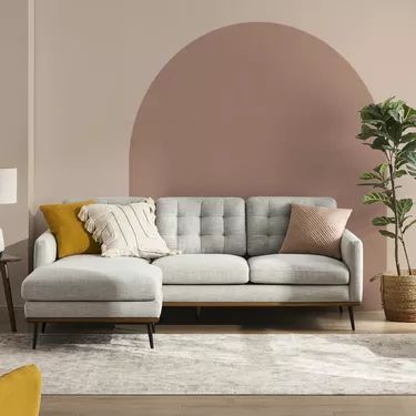 a living room with a couch, chair and potted plant