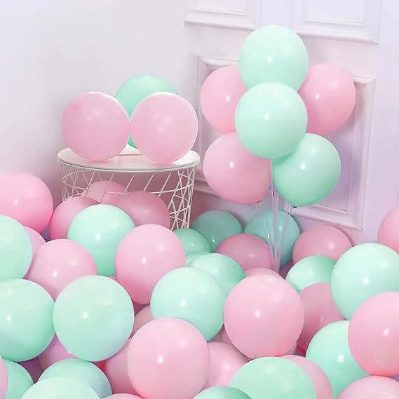 a room filled with pink and mint green balloons